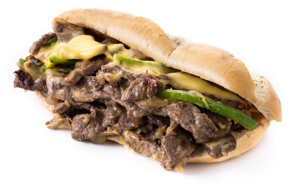 philly cheesesteak sandwich with beef cheesegreen pepers caramelized onion e1680884362473